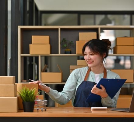 worker with clipboard in front of boxes